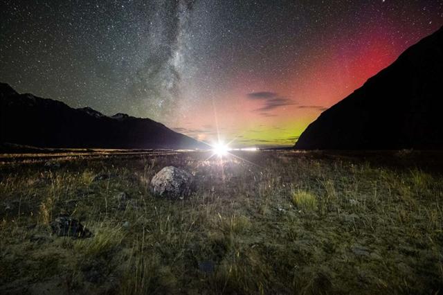 Khung cảnh đẹp như mộng với cực quang màu đỏ xanh và dải Ngân Hà chạy dọc trên bầu trời ở Vườn quốc gia Núi Cook ở New Zealand. Ảnh: Arief Rasa/Getty Images.
