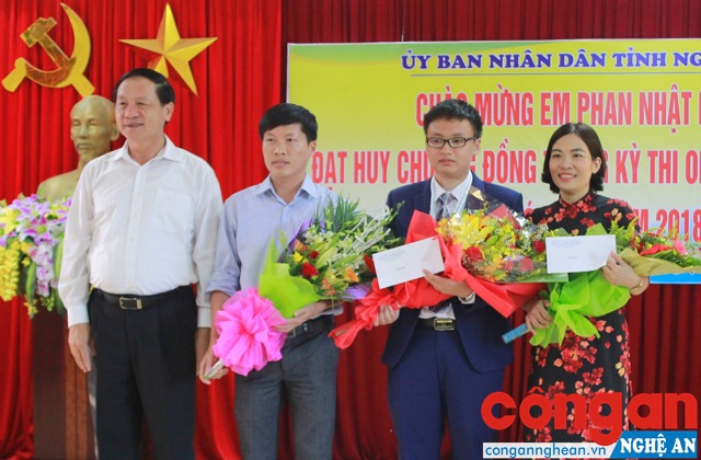 Đồng chí Lê Minh Thông, Phó Chủ tịch UBND tỉnh tặng hoa và quà chúc mừng thành tích của em Phan Nhật Duật và 2 thầy cô hướng dẫn
