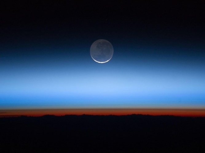 Bức ảnh không rõ ngày tháng của NASA cho thấy hình ảnh của mặt trăng cùng với tầng đối lưu, vùng đỉnh của tầng đối lưu và khí quyển Trái Đất.