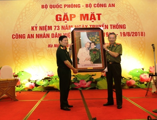 Bộ trưởng Ngô Xuân Lịch tặng Bộ trưởng Tô Lâm bức tranh Chủ tịch Hồ Chí Minh và Đại tướng Võ Nguyên Giáp.