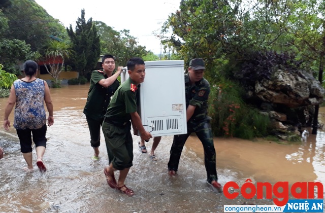 Lực lượng Công an và Bộ đội giúp người dân thị trấn Con Cuông, huyện Con Cuông vận chuyển đồ đạc ra khỏi vùng lũ - Ảnh: Trường Khuyên