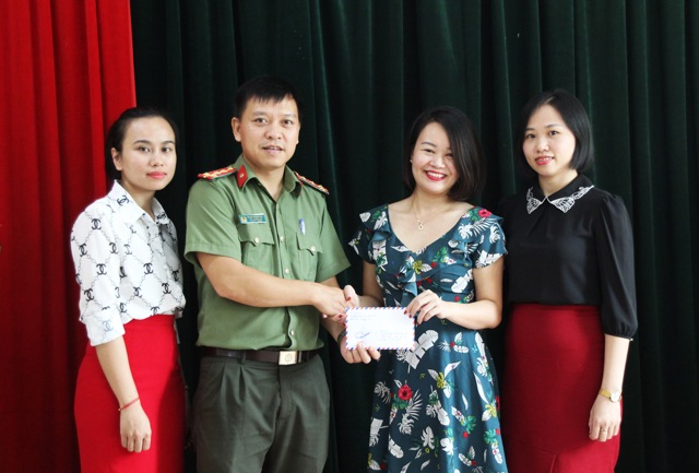 Bà Hoàng Thị Yến, Giám đốc Trung tâm trao tiền đấu giá tranh ủng hộ chương trình Tiếp sức đến trường do Báo Công an Nghệ An tổ chức