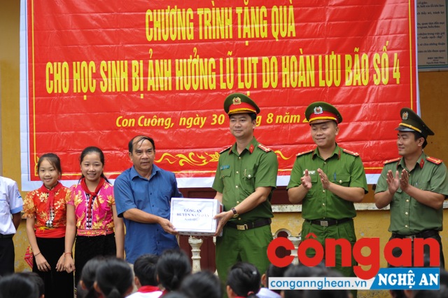 Đại úy Hoàng Ngọc Sỹ, Phó Trưởng Công huyện Nam Đàn trao các suất quà cho lãnh đạo trường PTDT Nội trú - THCS Con Cuông