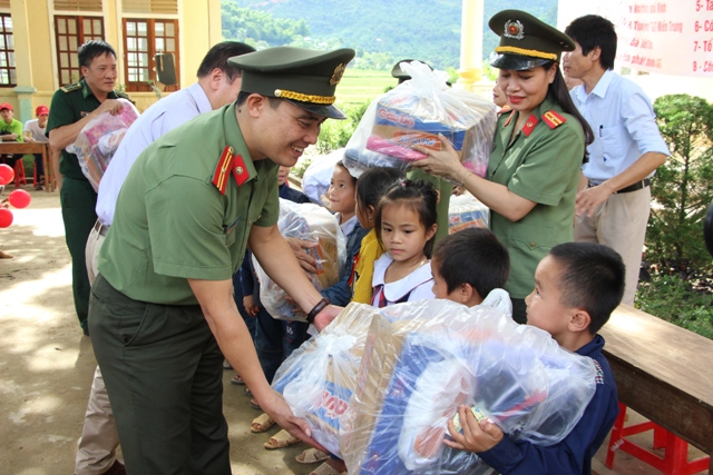 Thiếu tá Hồ Viết Dũng - Phó Tổng biên tập Báo Công an Nghệ An trao quà cho các em học sinh