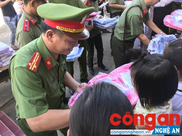 Thượng tá Nguyễn Hồng Tuyến - Trưởng Công an huyện Anh Sơn trao quà cho các em học sinh