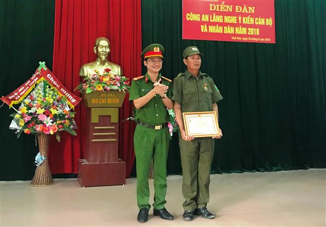 Trung tá Trần Ngọc Tuấn, Trưởng CA TX trao huân chương Vì an ninh Tổ quốc cho Công an viên xã Nghĩa Thuận