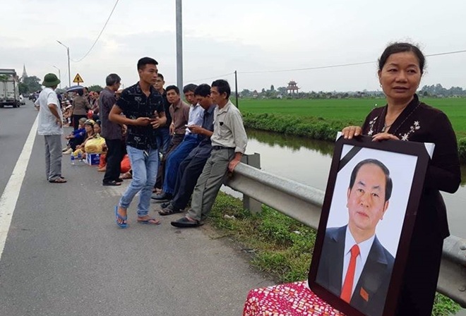 Trên tuyến QL10 hướng về xã Quang Thiện, huyện Kim Sơn, đông đảo người dân đứng 2 bên đường chờ đón linh cữu Chủ tịch nước. Nhiều ban thờ được lập bên đường.