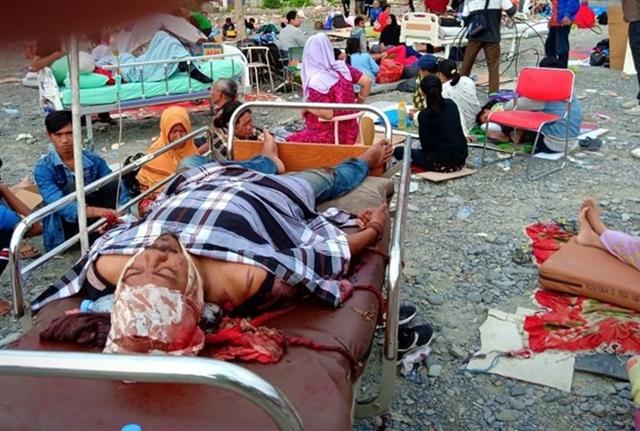 Người bị thương nằm la liệt tại các khu cấp cứu dựng tạm. Nhằm hỗ trợ các nạn nhân tại Palu và Donggala gần tâm chấn, Bộ trưởng Các vấn đề Xã hội Agus Gumiwang Kartasasmita đã cùng một đội ngũ lập 6 bếp ăn lưu động và lều tạm trú. Ảnh: Reuters