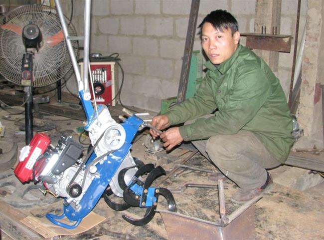 Anh Nguyễn Văn Tuấn với mô hình máy nông nghiệp đa năng đang lắp ráp.