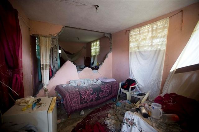 Một chiếc giường đầy những mảnh gạch vỡ của bức tường ngay bên cạnh khi trận động đất 5,9 độ xảy ra. Ảnh: AP