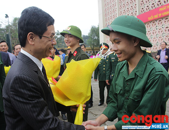 Đồng chí Nguyễn Xuân Sơn, Phó Bí thư Thường trực Tỉnh ủy, Chủ tịch HĐND tỉnh tặng hoa chúc mừng chiến sỹ tại lễ nhận quân TP Vinh năm 2018