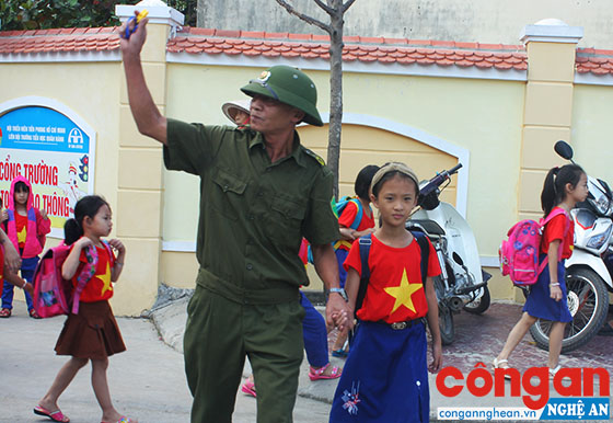 Hội Cựu chiến binh thị trấn Quán Hành hướng dẫn học sinh qua đường