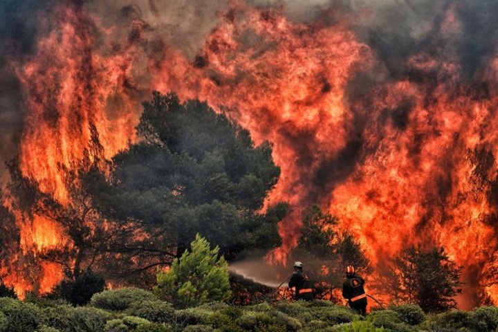 Những người lính cứu hỏa đang nỗ lực để xử lý đám cháy ở làng Kineta, gần thủ đô Athens, Hy Lạp ngày 24/7/2018. Vụ cháy rừng nghiêm trọng này đã khiến nhiều người thiệt mạng, trong đó có cả trẻ nhỏ, phá hủy nhiều ngôi nhà và thiêu rụi các cánh rừng. Ảnh: AFP
