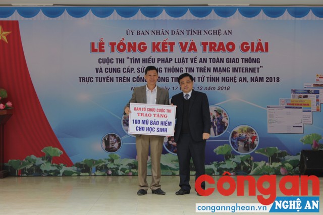 Đồng chí Huỳnh Thanh Điền - Phó Chủ tịch UBND tỉnh và đồng trao 100 mũ bảo hiểm cho các học sinh đạt giải cao trong cuộc thi của Trường THPT Nguyễn Xuân Ôn.