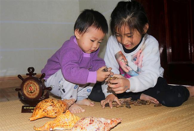 Niềm vui của hai đứa trẻ, con của anh Lê Hồng Tuấn trú tại xã Nghi Thái,  huyện Nghi Lộc khi ngày Tết bố trở về mang theo những kỷ vật Trường Sa