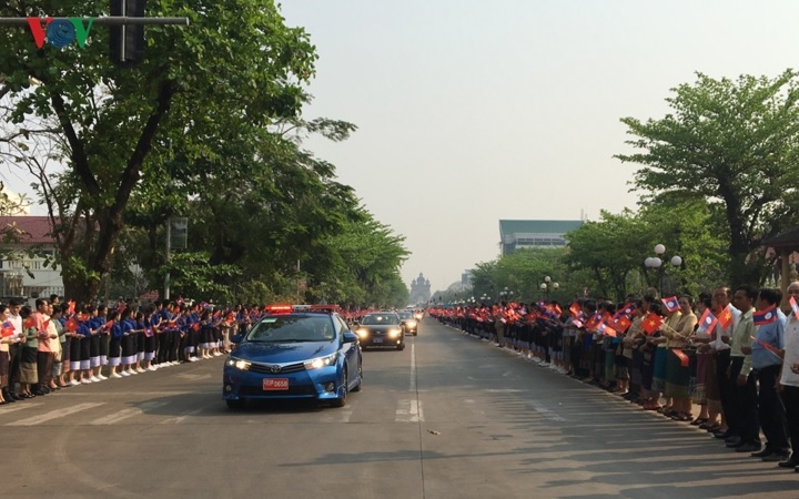  Các tầng lớp nhân dân thủ đô Vientiane vẫy cờ hoa chào đón đoàn xe chở Tổng Bí thư, Chủ tịch nước Nguyễn Phú Trọng.