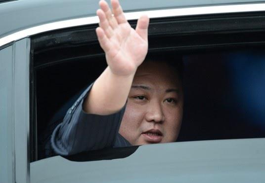 Vẫy tay chào đáp lại sự chào đón nhiệt liệt của người dân, Chủ tịch Triều Tiên Kim Jong-un di chuyển về Hà Nội.