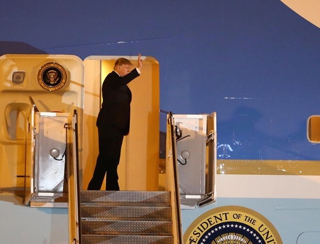 Tổng thống Trump tươi cười vẫy chào mọi người khi bước ra khỏi chiếc Air Force One tại sân bay Nội Bài tối 26-2.