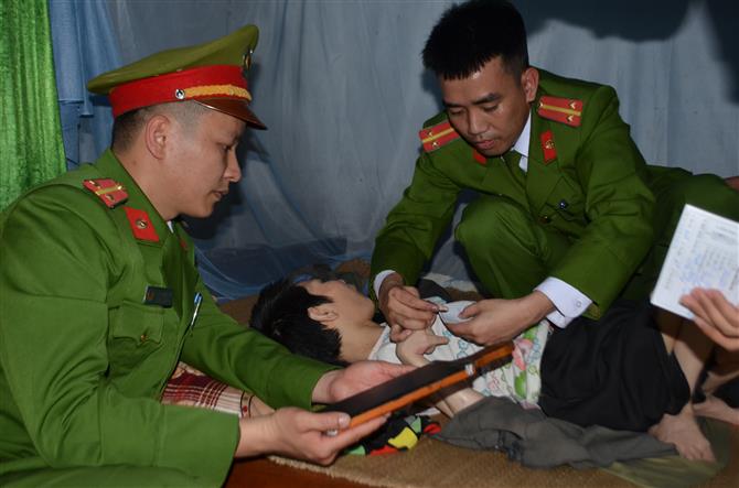 Tổ công tác lăn tay cho Chị Nguyễn Thị Hải, 38 tuổi, bị nhiễm chất độc da cam, nằm một chỗ. 