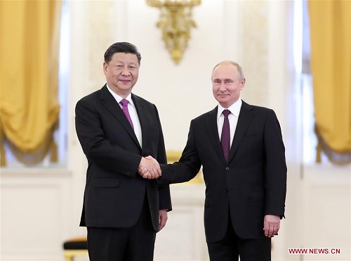 Chủ tịch Trung Quốc Tập Cận Bình (trái) và Tổng thống Nga Vladimir Putin bắt tay nhau trước khi bước vào đối thoại tại Moscow, ngày 5/6. (Ảnh: Xinhua)