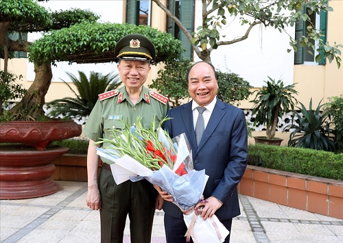 Bộ trưởng Tô Lâm tặng hoa Thủ tướng Chính phủ Nguyễn Xuân Phúc.
