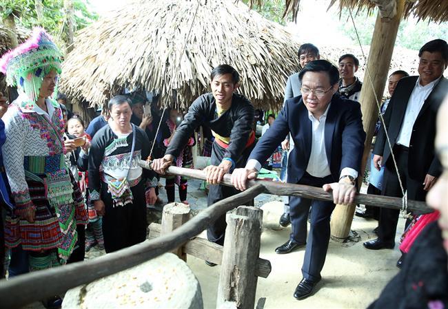 Phó Thủ tướng Vương Đình Huệ tham gia trải nghiệm xay gạo ở chợ người Mông, bản Sin Suối Hồ, Lai Châu. Ảnh: VGP