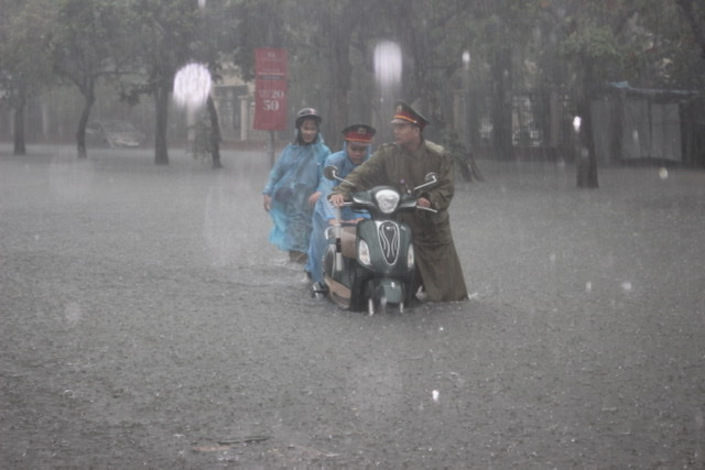 Giúp đỡ một phụ nữ giữa mưa to và nước lớn