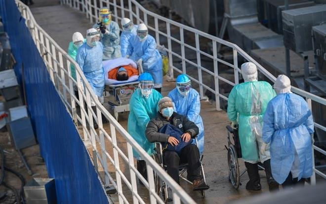 Các nhân viên y tế tại một bệnh viện ở Vũ Hán đang vận chuyển các bệnh nhân nghi nhiễm Covid-19.