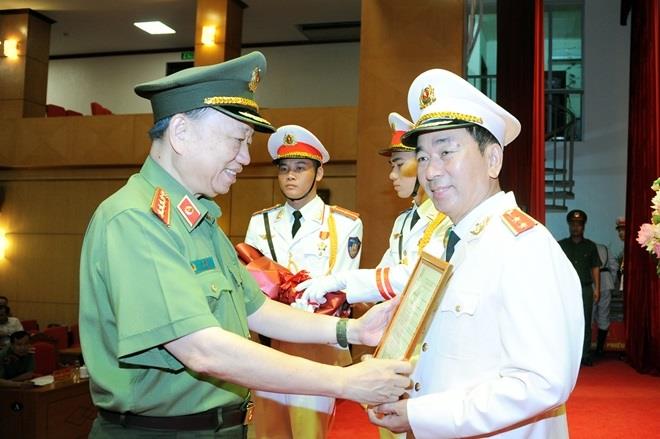 Bộ trưởng Tô Lâm trao Quyết định của Chủ tịch nước thăng cấp bậc hàm từ Thiếu tướng lên Trung tướng đối với đồng chí Trần Quốc Tỏ.