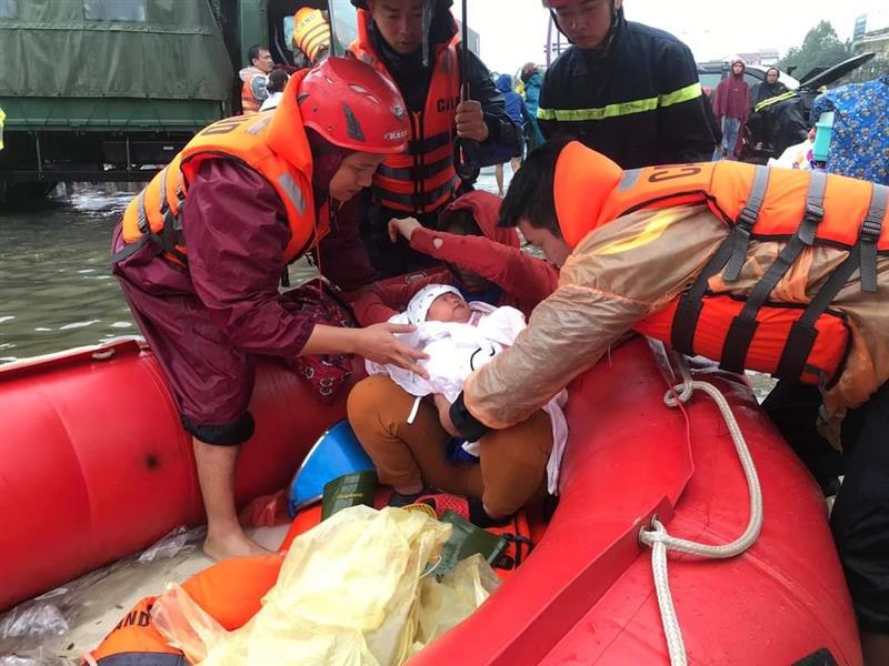 cán bộ, chiến sỹ Công an Nghệ An phối hợp cùng Công an Hà Tĩnh giúp đỡ người dân bị ngập lụt đến nơi an toàn