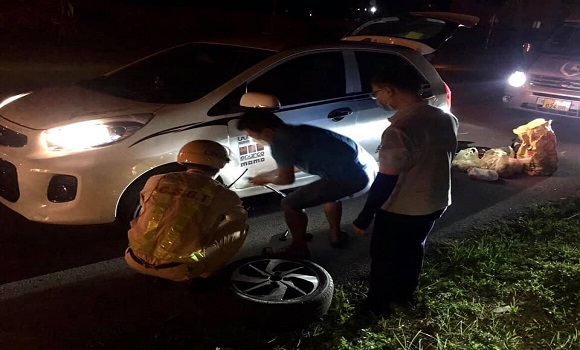 Cảnh sát giao thông giúp người tham gia giao thông thay lốp xe trong đêm