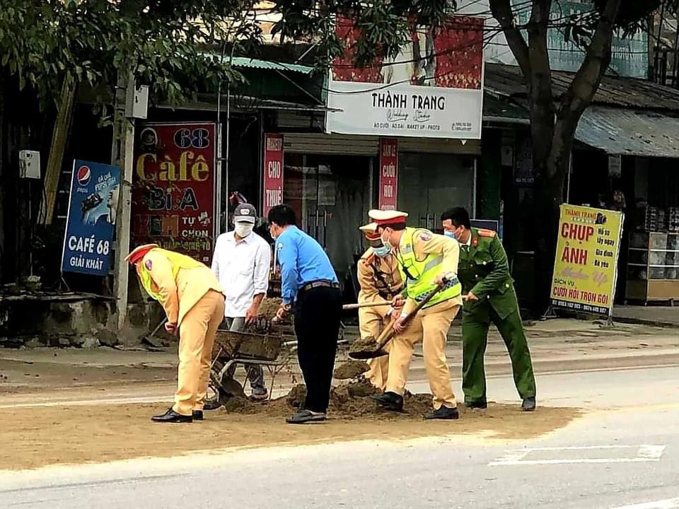 Đội Cảnh sát giao thông - trật tự Công an huyện Nam Đàn giúp dân thu gom vật liệu rơi vãi trên đường