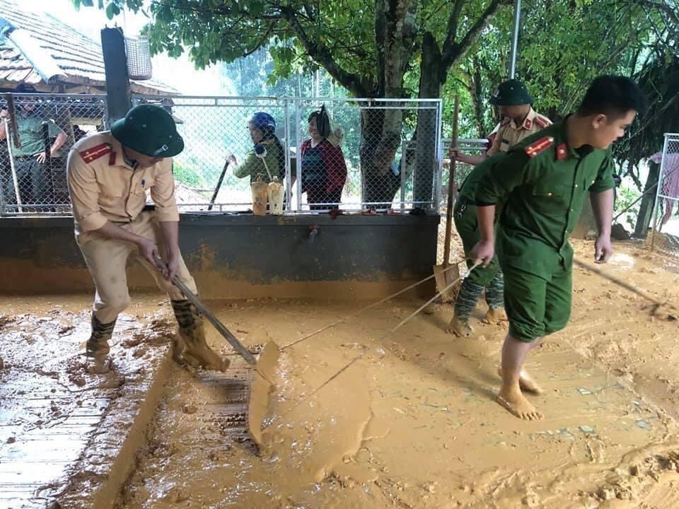 Đội Cảnh sát Giao thông Công an huyện Anh Sơn giúp người dân dọn bùn đất sau mưa lũ
