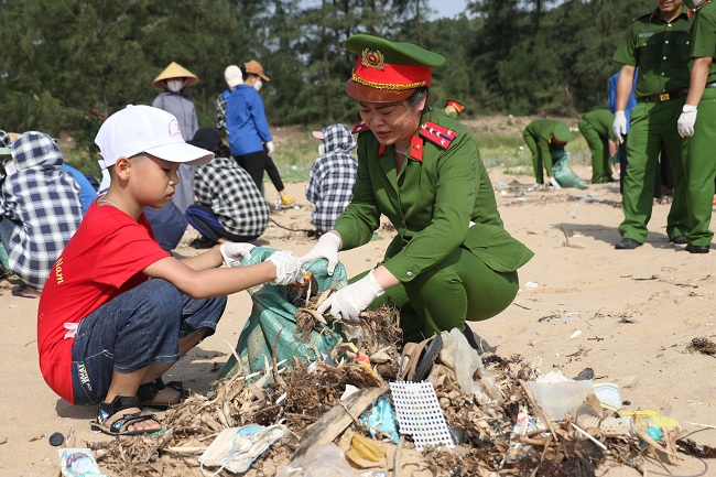 Cháu bé theo mẹ tham gia gom rác bãi biển - Đây cũng là dịp để các nữ đoàn viên công đoàn giáo dục cho con trẻ về ý thức bảo vệ môi trường