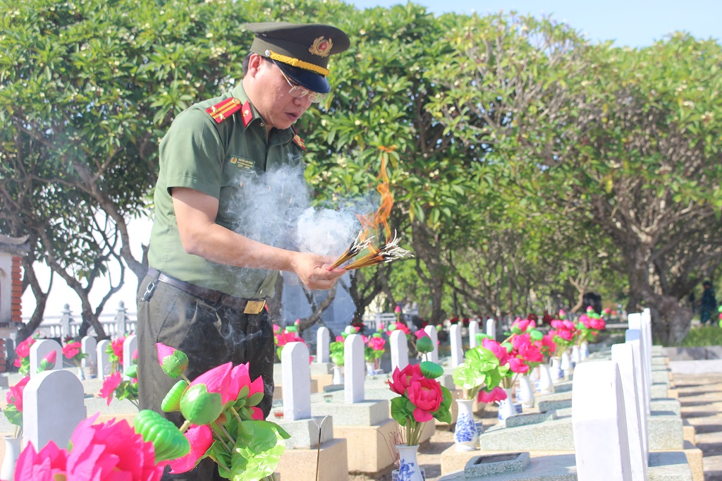 Các đồng chí: Trung tá Bùi La Sơn, Trung tá Nguyễn Anh Đông, Phó Trưởng phòng Tham mưu dâng hương lên các phần mộ liệt sĩ