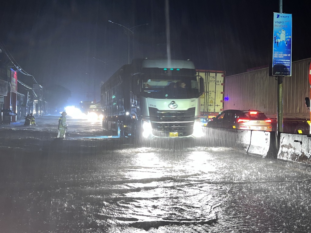 Trạm Cảnh sát giao thông Diễn Châu làm nhiệm vụ phân luồng, cảnh báo các phương tiện khi lưu thông qua khu vực ngập từ 40 - 50cm trên tuyến Quốc lộ 1A, khu vực thị trấn Cầu Giát, huyện Quỳnh Lưu vào đêm 29/9/2022