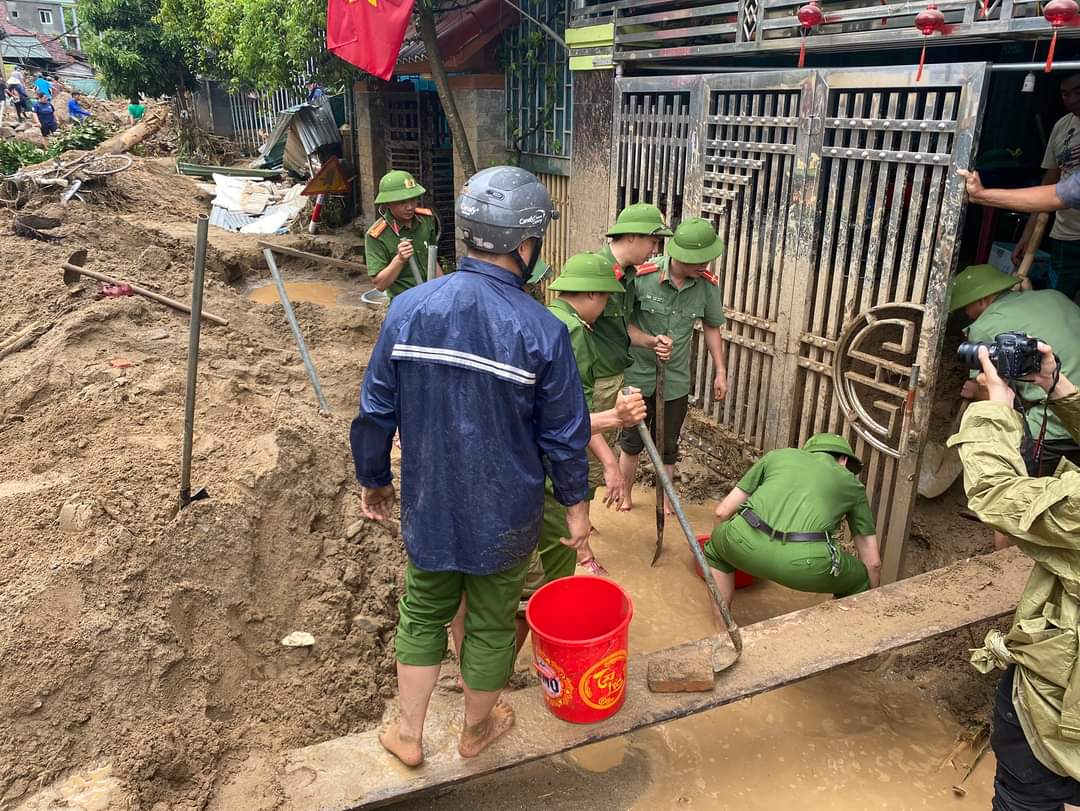 Cán bộ, chiến sĩ trẻ có mặt tại nhiều khu vực ngập lụt thuộc thị trấn Mường Xén để giúp dọn dẹp rác thải, bùn đất