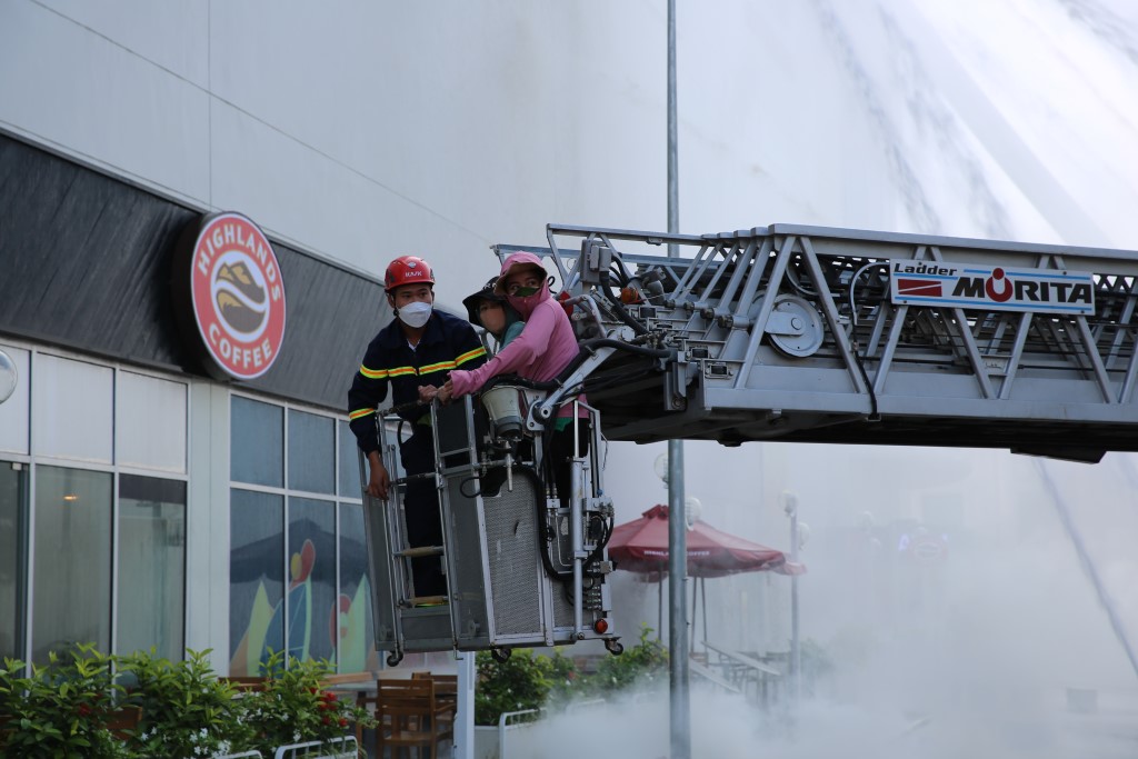Lực lượng chữa cháy dùng xe thang chuyên dụng để đưa người mắc kẹt trên toà nhà ra ngoài an toàn