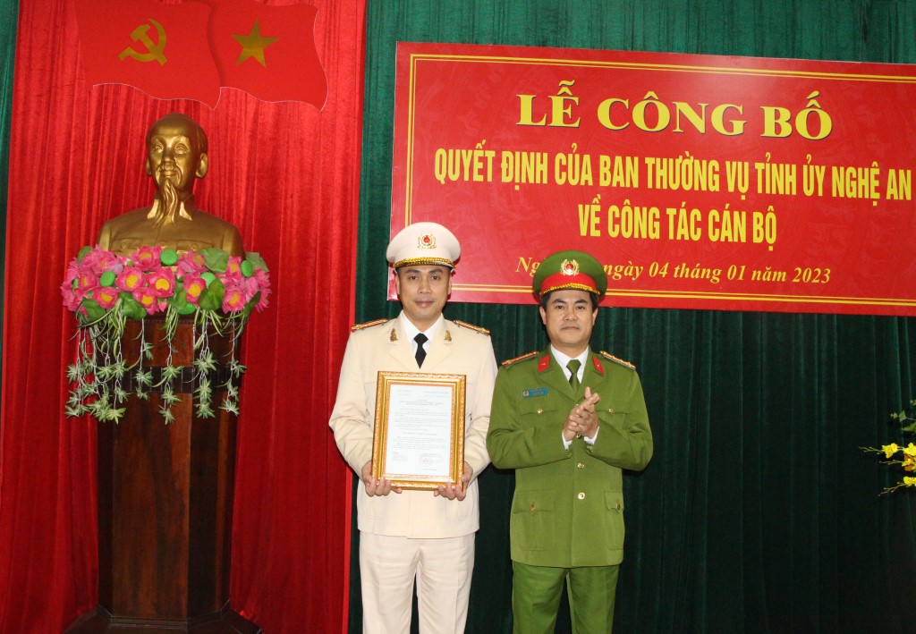 Đồng chí Đại tá Nguyễn Đức Hải, Phó Giám đốc Công an tỉnh trao Quyết định và tặng hoa chúc mừng đồng chí Thượng tá Đặng Viết Mạnh