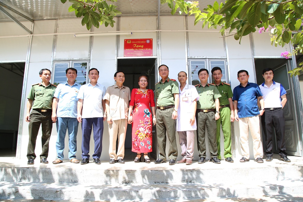 Đoàn công tác Công an tỉnh và đại diện nhà tài trợ chụp ảnh lưu niệm tại Nhà điều trị Trạm y tế xã Nhôn Mai, huyện Tương Dương