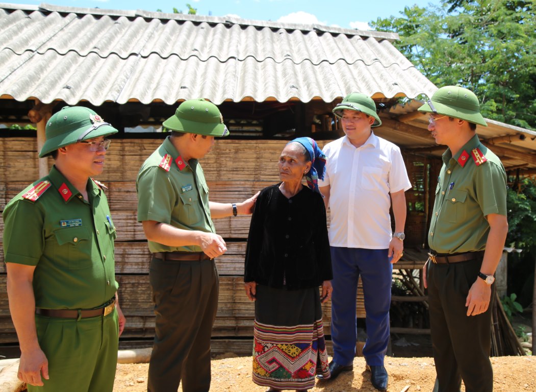 Đoàn công tác trao đổi với một người dân ở xã Châu Khê, huyện Con Cuông (phía sau là căn nhà cũ đã gần đổ sập)  