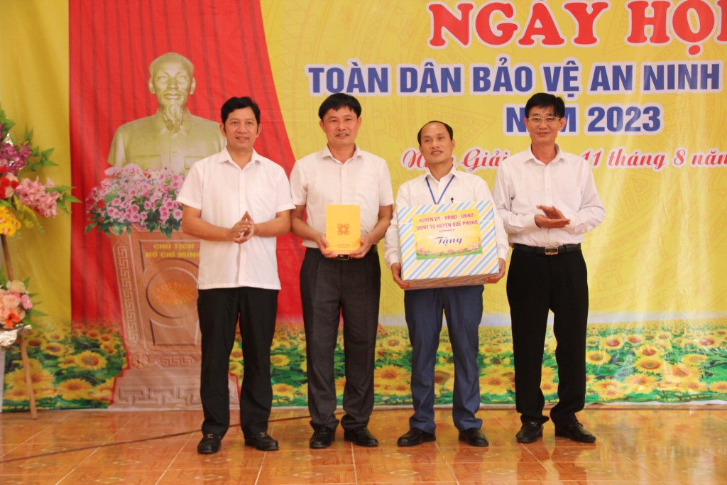 Đồng chí Đại tá Nguyễn Duy Thanh, Phó Giám đốc Công an tỉnh và chính quyền huyện Quế Phong trao quà tặng chính quyền và bà con Nhân dân xã Nậm Giải 