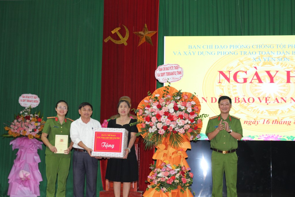 Đồng chí Đại tá Trần Ngọc Tuấn, Phó Giám đốc Công an tỉnh trao hoa và quà tặng cấp ủy, chính quyền xã