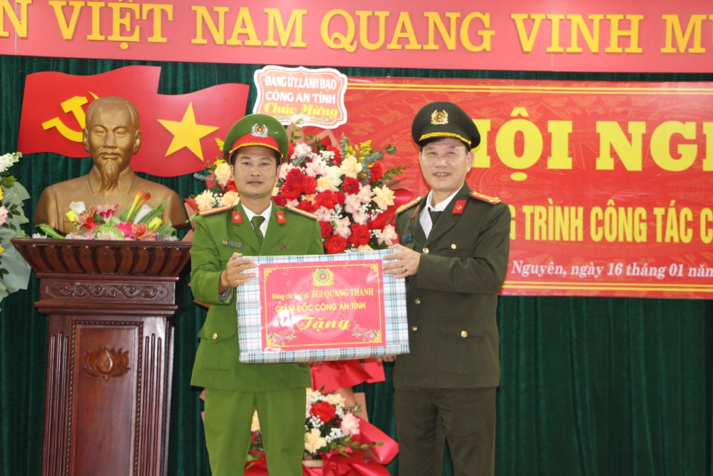 Đồng chí Đại tá Lê Văn Thái, Phó Giám đốc Công an tỉnh trao quà của Giám đốc Công an tỉnh tặng Công an xã Hưng Trung