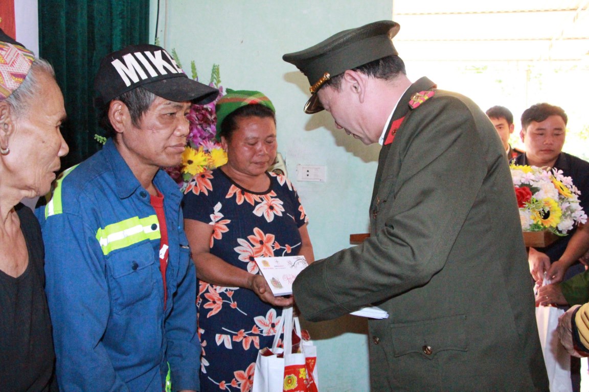 Đồng chí Đại tá Lê Văn Thái, Phó Giám đốc Công an tỉnh trao quà cho các hộ nghèo tại xã Hữu Khuông