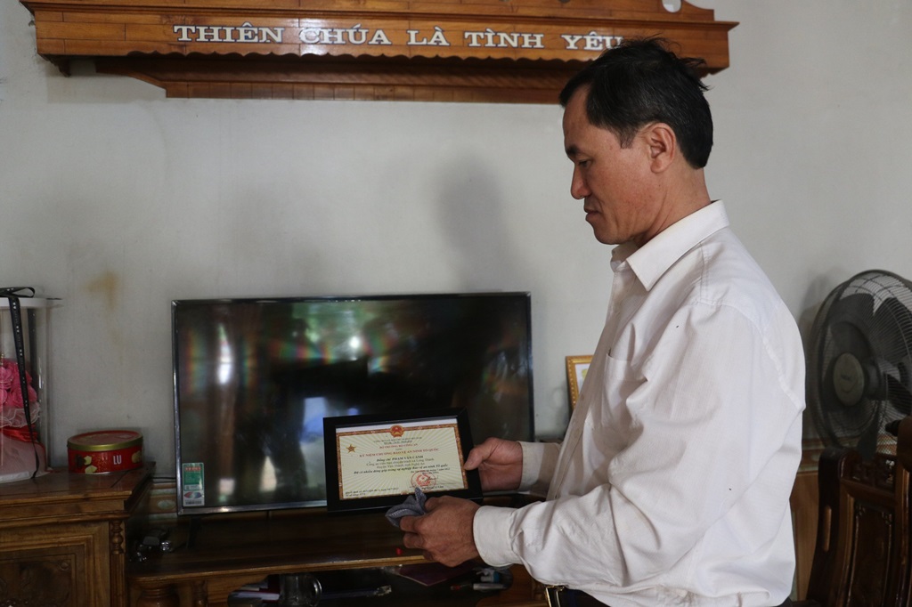 Ông Phạm Văn Cảnh, công an viên bán chuyên trách xã Long Thành nâng niu Kỷ niệm chương bảo vệ An ninh Tổ quốc mà Bộ trưởng Bộ Công an tặng cho mình