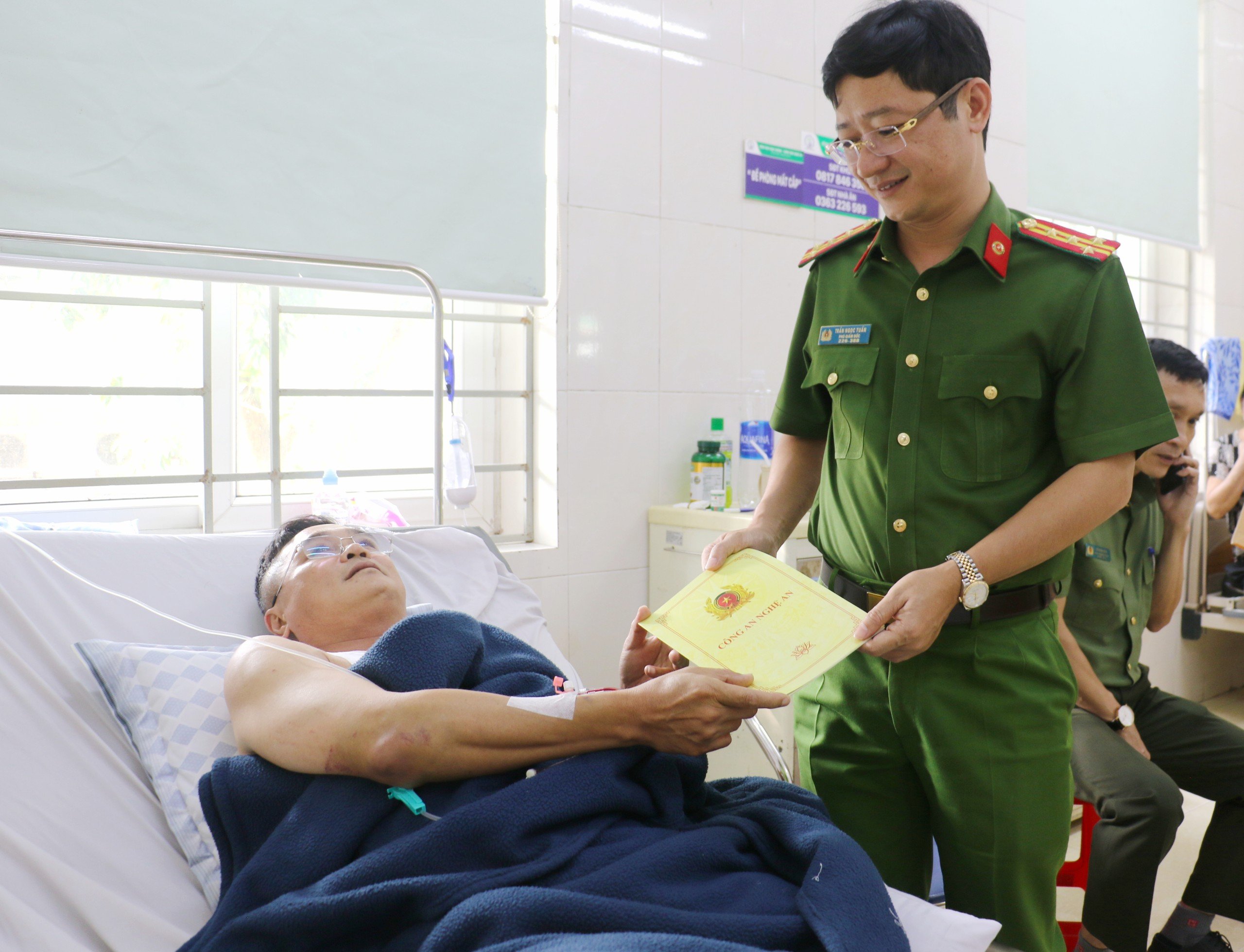 Đồng chí Đại tá Trần Ngọc Tuấn chia sẻ, động viên và tặng quà Trung tá Hoàng Quang Vinh sớm bình phục