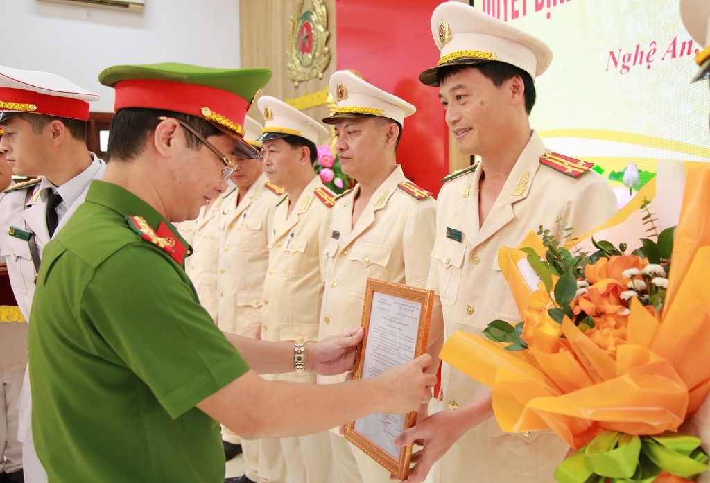 Đồng chí Đại tá Trần Ngọc Tuấn, Phó Giám đốc Công an tỉnh trao Quyết định và tặng hoa chúc mừng