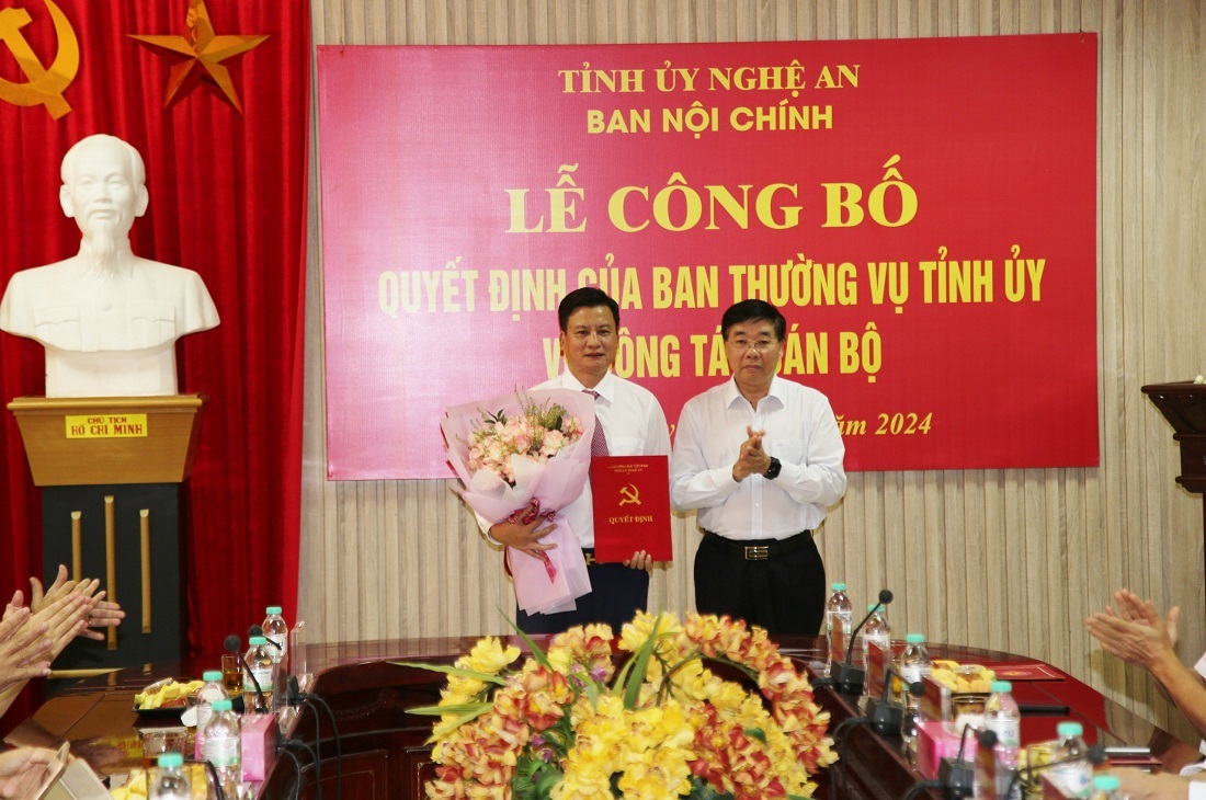 Đồng chí Nguyễn Văn Thông, Phó Bí thư Thường trực Tỉnh ủy trao Quyết định, tặng hoa chúc mừng Phó Trưởng Ban Nội chính Tỉnh ủy Phạm Vũ Cường