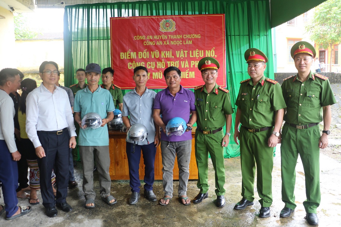 Đồng chí Đại tá Trần Ngọc Tuấn, Phó Giám đốc Công an tỉnh trao mũ bảo hiểm tặng những người dân giao nộp và đổi vũ khí, vật liệu nổ, công cụ hỗ trợ và pháo  